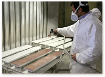 un empleado barniza la madera manualmente